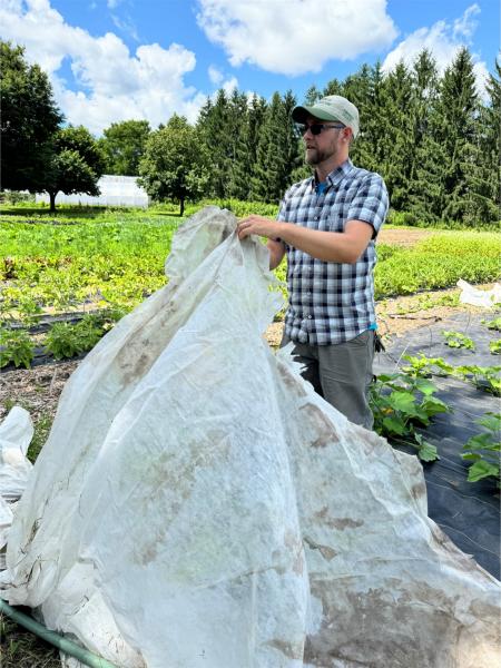 Mike Smith showing a cover that is used to protect the plants from being eaten by animals